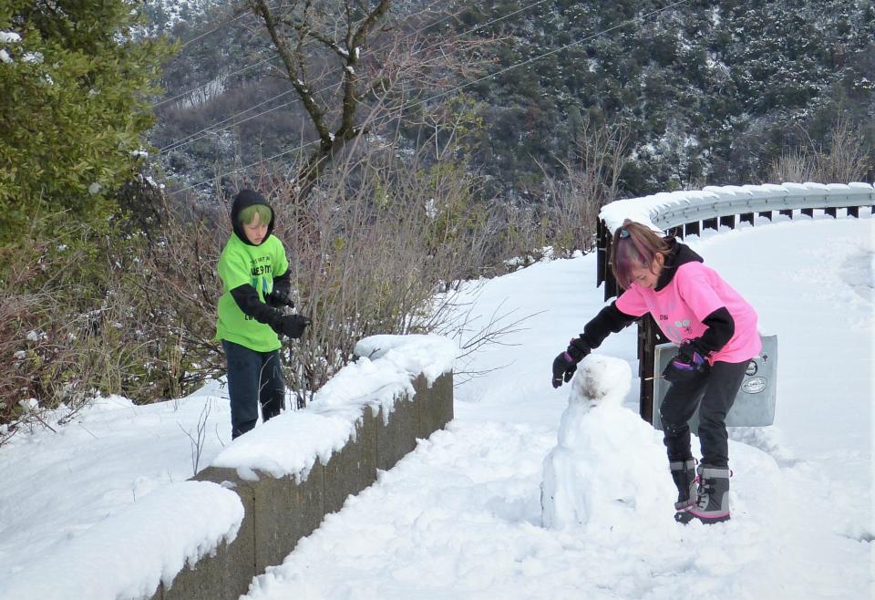 Hunter, left, and RyRy Hackworth play in the snow at the Shasta Dam overlook north of Redding on Monday.