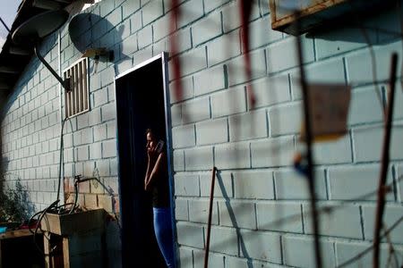 Alejandra Jordan, 30, talks on the phone before her sterilization surgery at the door of her house in San Francisco de Yare, Venezuela July 11, 2016. REUTERS/Carlos Garcia Rawlins