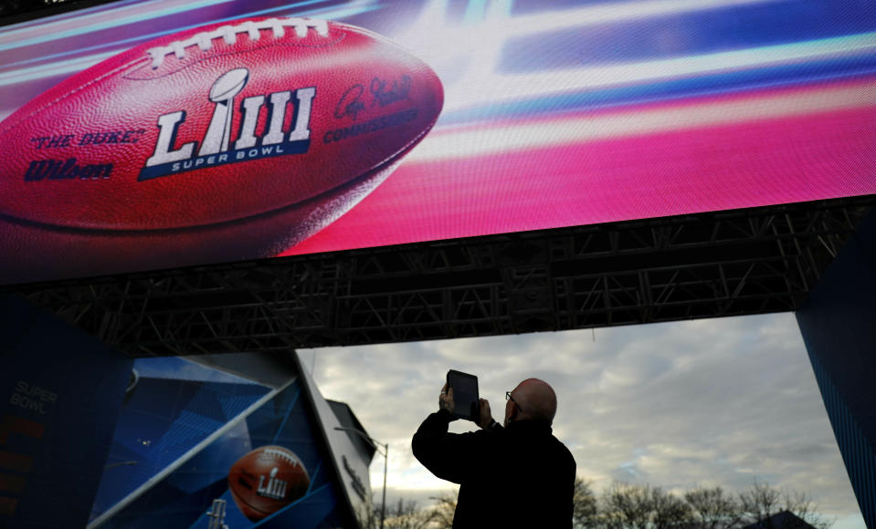 Frank Egdmann, of Kiel, Germany, takes a photo of Mercedes-Benz Stadium ahead of Sunday's NFL Super Bowl 53 football game between the Los Angeles Rams and New England Patriots in Atlanta, Saturday, Feb. 2, 2019. (AP Photo/David Goldman)