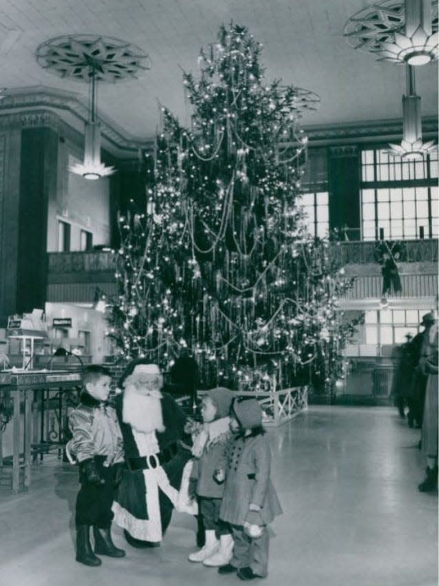 Santa Claus chats with Gary Lee Stevens, 5, Eddie Ambrus, 3, and Nancy Scherr, 3, at the First National Tower in downtown Akron in 1950.