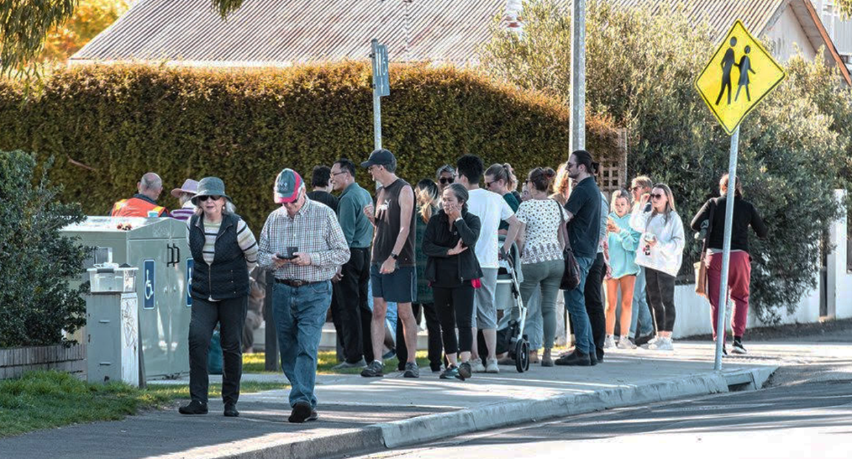 A crowd of people in Hobart crowding around an unseen seal.