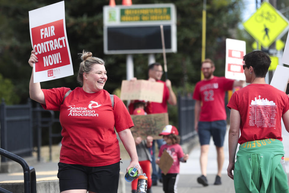 Lucy Magidman, wife of teacher Michael Magidman, shows her support as teachers from Seattle Public Schools picket outside Roosevelt High School on what was supposed to be the first day of classes, Wednesday, Sept. 7, 2022, in Seattle. The first day of classes at Seattle Public Schools was cancelled and teachers are on strike over issues that include pay, mental health support, and staffing ratios for special education and multilingual students. (AP Photo/Jason Redmond)