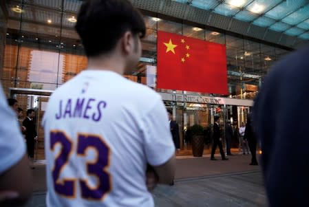 Man wearing a T-shirt with name and number of LeBron James of NBA Los Angeles Lakers stands outside a Ritz-Carlton hotel in Shanghai,