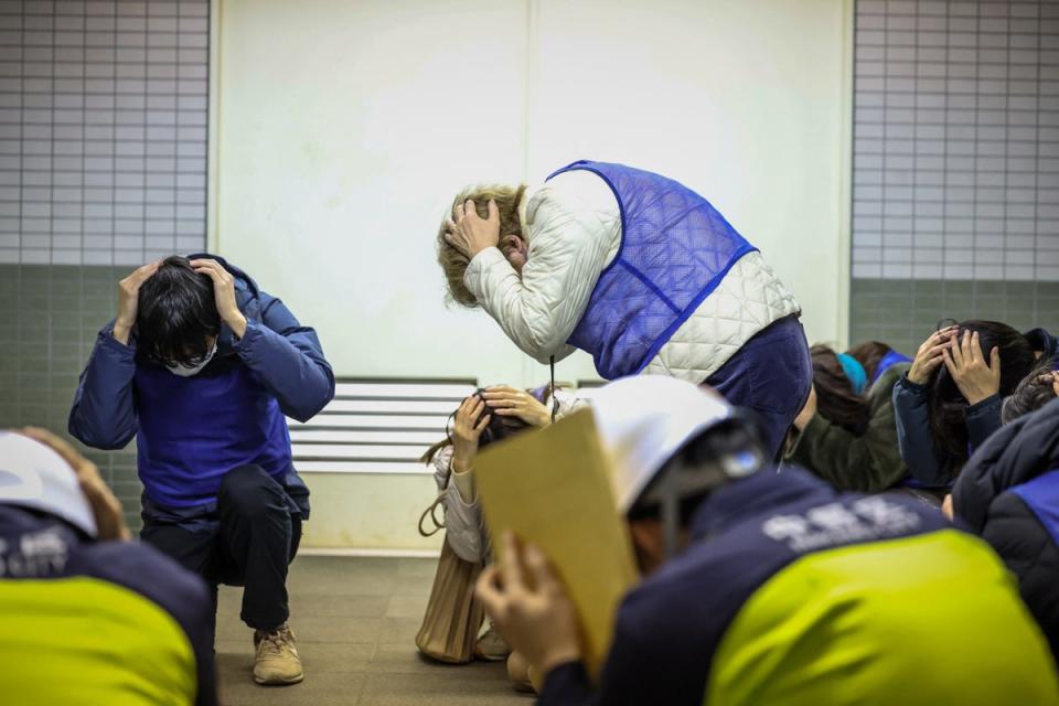 Residents are seen moving through the Toei Subway Higashi-Nakano Station during a security drill for the evacuation of residents and others to underground stations after a J-Alert is issued, in Tokyo (POOL/AFP via Getty Images)