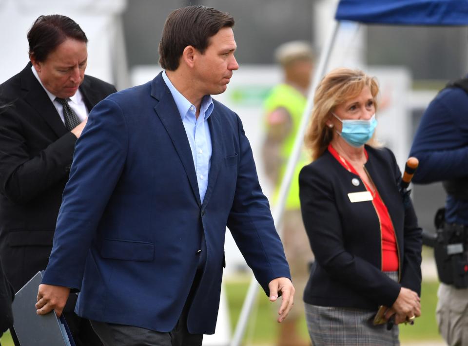 Gov. Ron DeSantis walks toward a podium, accompanied by Manatee County Commissioner Vanessa Baugh, for a press conference in Lakewood Ranch.