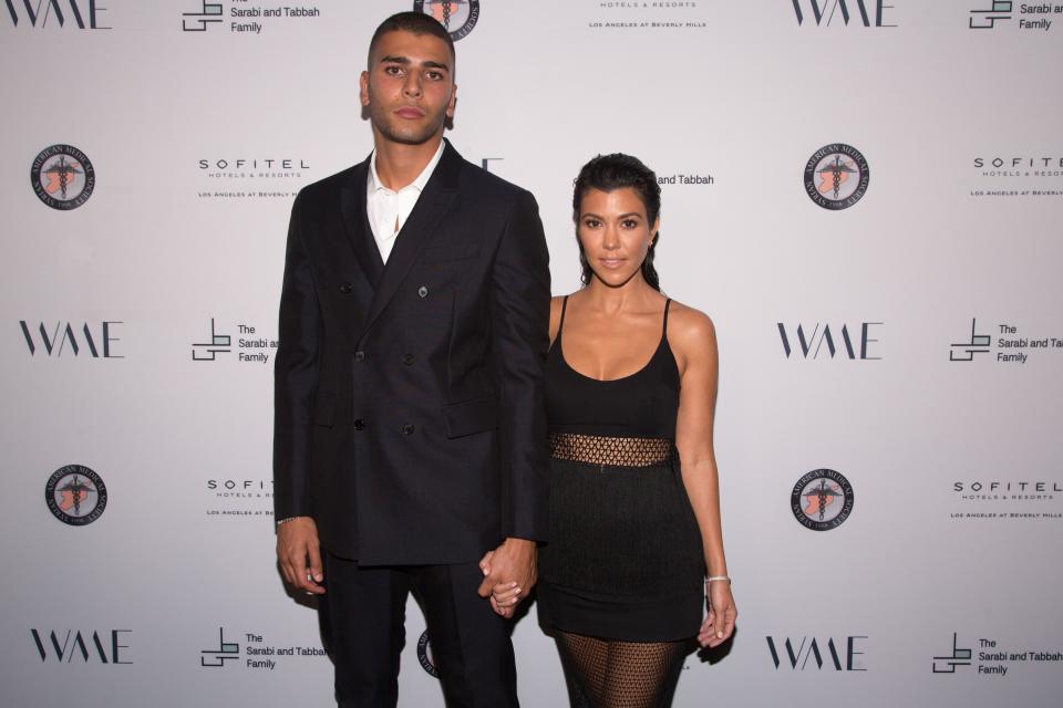 Younes Bendjima steps out in style in a black suit and pant with the love of his life, Kourtney Kardashian in a low-cut new dress that leaves nothing to imagination.