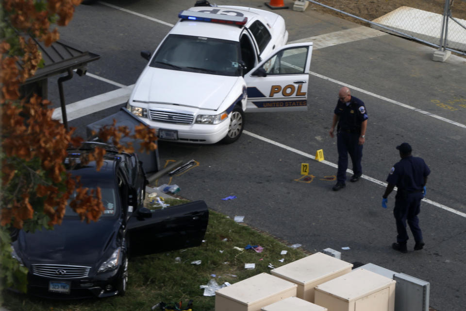 Capitol Hill police officers look at a car following a shooting on Capitol Hill in Washington, Thursday, Oct. 3, 2013. A police officer was reported injured after gunshots at the U.S. Capitol, police said Thursday. They locked down the entire complex, at least temporarily derailing debate over how to end a government shutdown. (Charles Dharapak/AP)