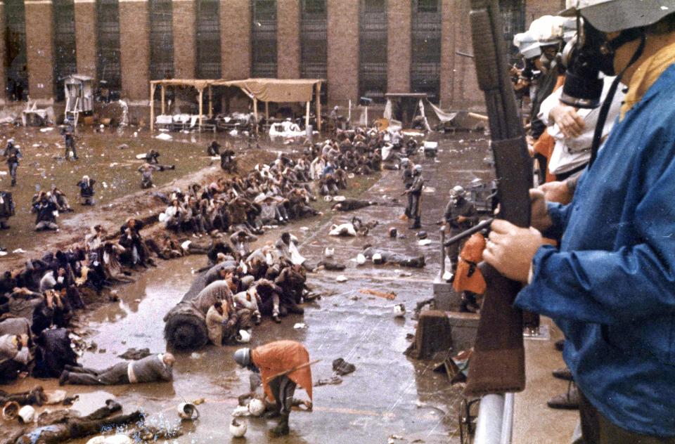 FILE — State police in riot gear regain control of prisoners following the Attica prison riot in Attica, New York, Sept. 1971. The riot, in which 43 were killed, lasted four days during which guards were held as hostages. New York authorities have lifted a ban that had stopped state prison inmates from reading a book about the 1971 Attica Correctional Facility uprising following a First Amendment lawsuit brought by its author. (AP Photo, File)