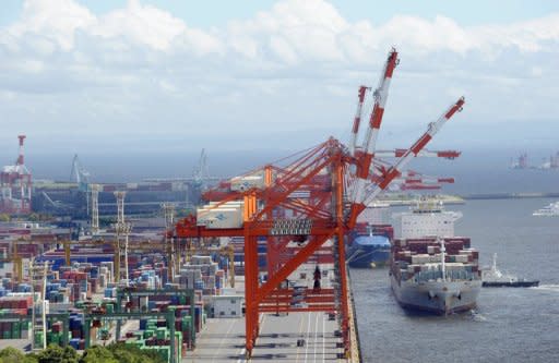 A freighter (R) comes in to dock alongside a container wharf in Tokyo port. Japan logged a bigger-than-expected trade deficit of about $11.5 billion in May as the nation's energy costs soared, official data showed Wednesday