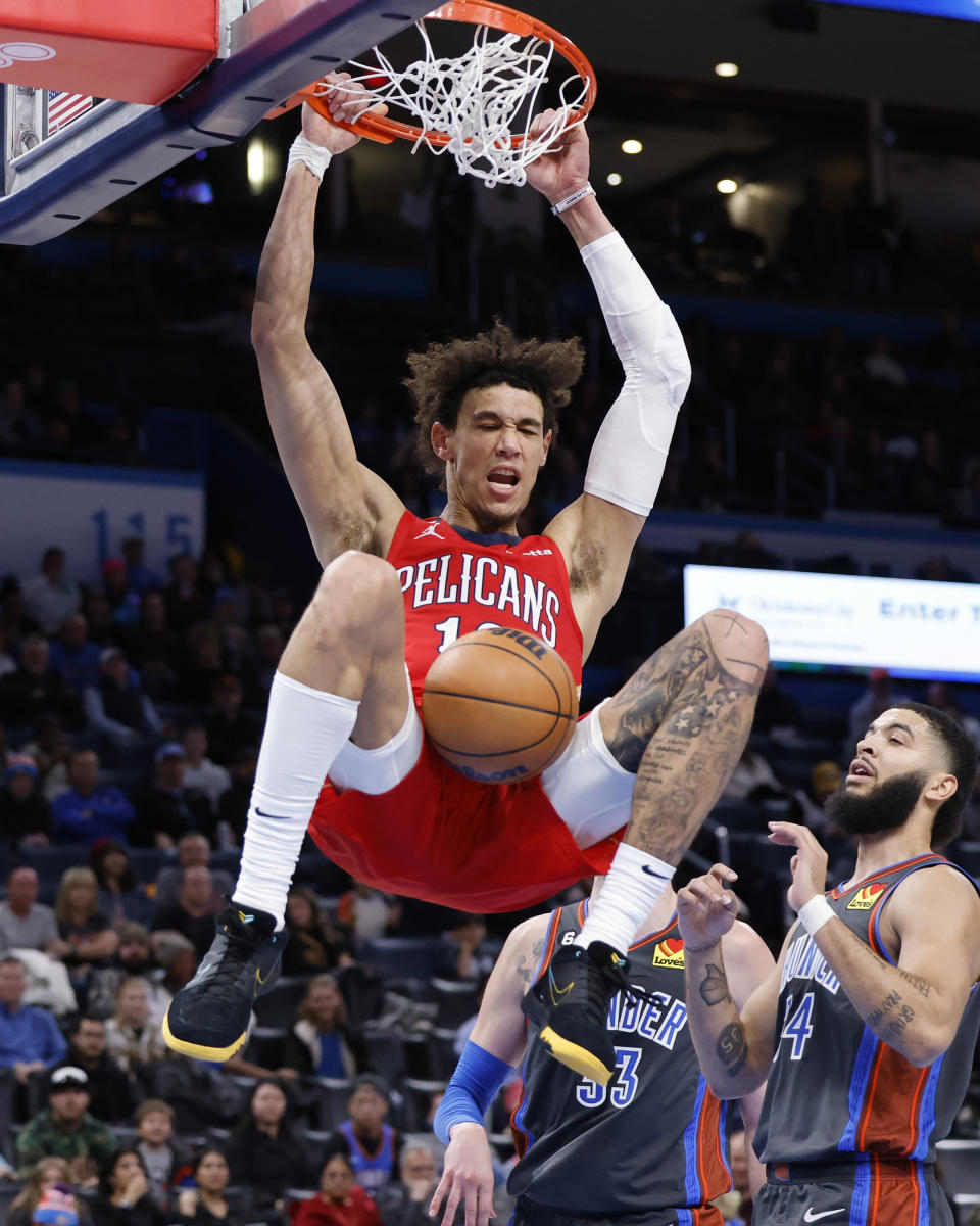 New Orleans Pelicans center Jaxson Hayes, top, dunks while Oklahoma City Thunder center Mike Muscala and forward Kenrich Williams look on during the second half of an NBA basketball game Friday, Dec. 23, 2022, in Oklahoma City. (AP Photo/Garett Fisbeck)