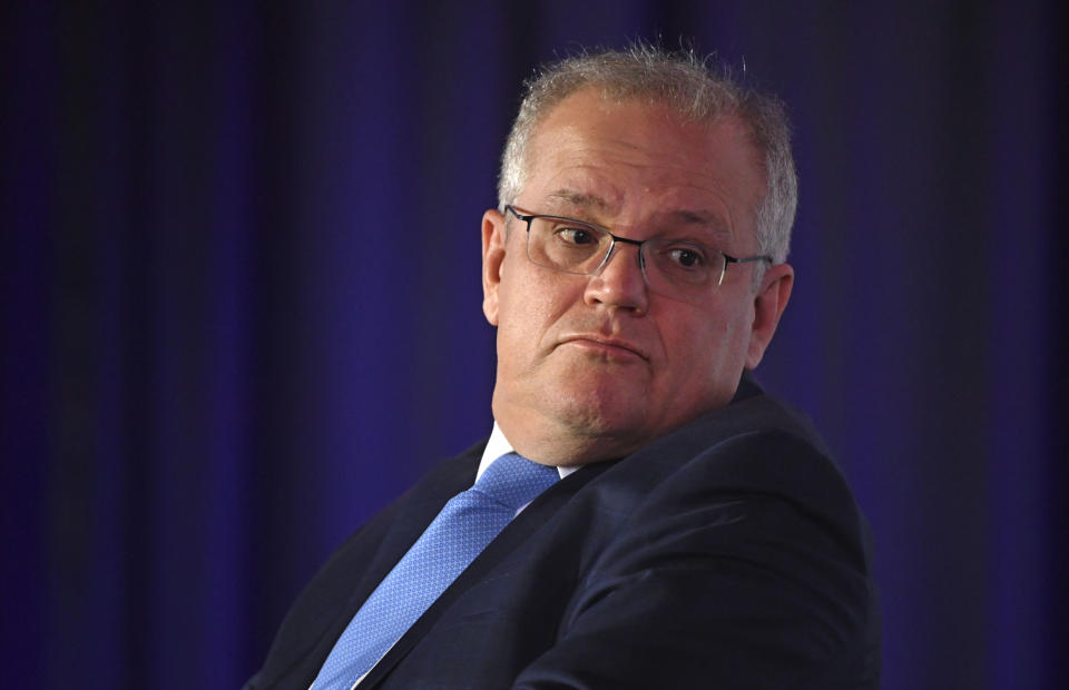 Australian Prime Minister Scott Morrison looks over his shoulder as he attends a bush summit in Cooma, Friday, Aug. 28, 2020. Morrison said he was open to allowing an Australian white supremacist who slaughtered 51 worshippers at two New Zealand mosques to serve his life sentence in his homeland but the victims' wishes would be paramount. (Mick Tsikas/AAP Image via AP)