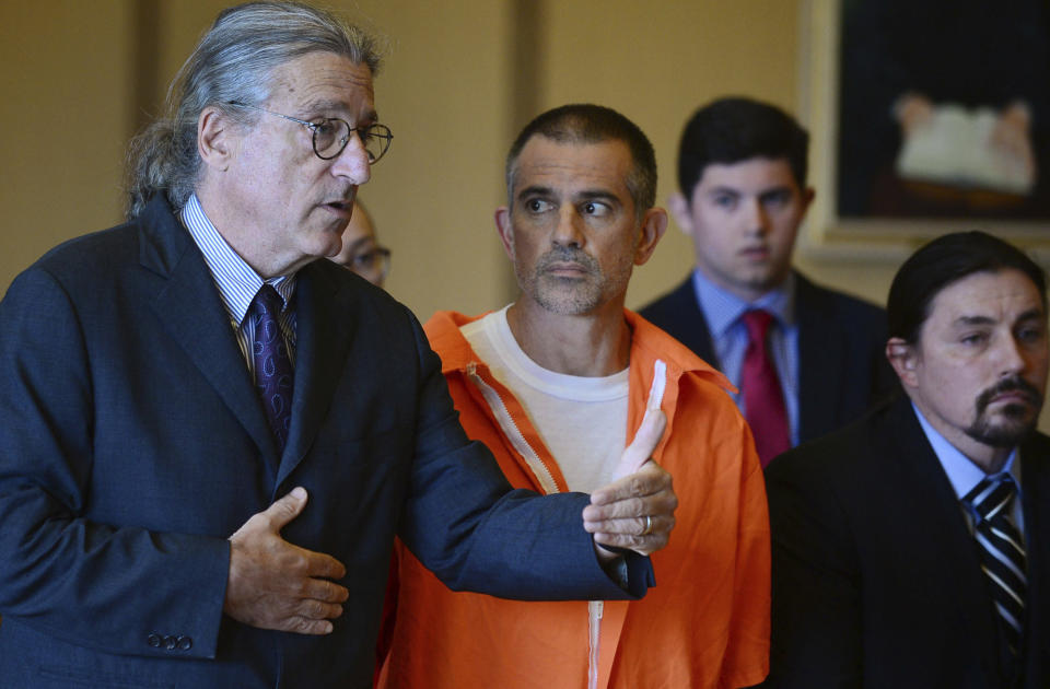 Fotis Dulos, center, listens, as his attorney Norm Pattis, left, addresses the court during a hearing at Stamford Superior Court, Tuesday, June 11, 2019 in Stamford, Conn. Fotis Dulos, and his girlfriend, Michelle Troconis, have been charged with evidence tampering and hindering prosecution in the disappearance of his wife Jennifer Dulos. The mother of five has has been missing since May 24. (Erik Trautmann/Hearst Connecticut Media via AP, Pool)