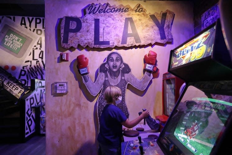 Max Cobb, 9, tries his hand at an arm wrestling video game at the new Play Arcade Bar & Restaurant on Union Street in downtown New Bedford.