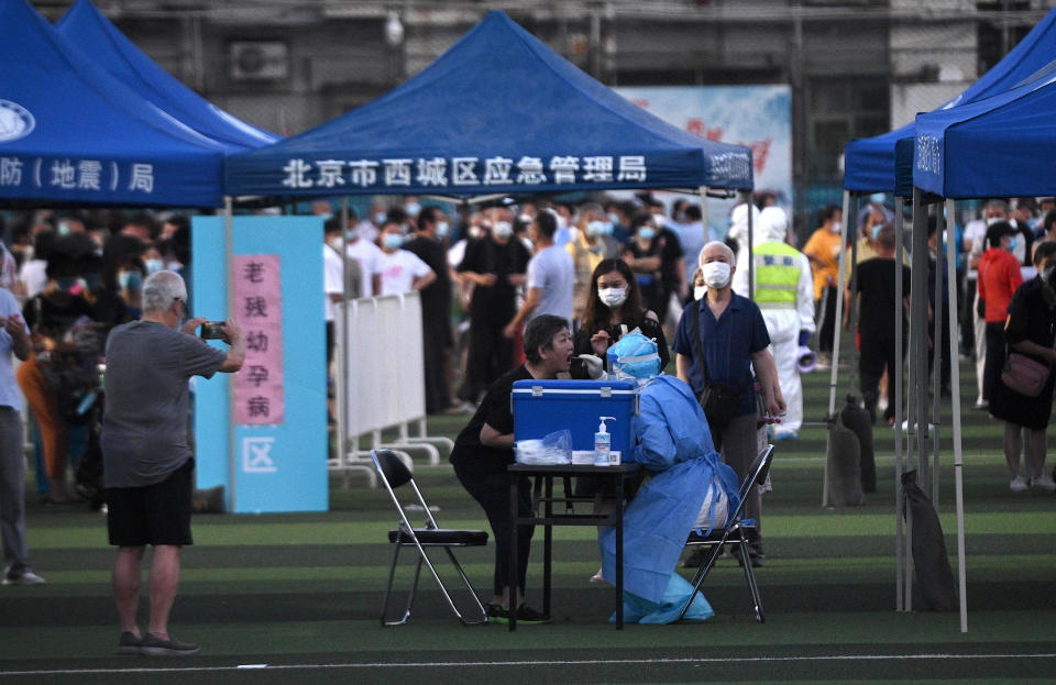 Image: People who visited or live near Xinfadi Market queue for a swab test at Guangan Sport Center in Beijing (Noel Celis / AFP - Getty Images)