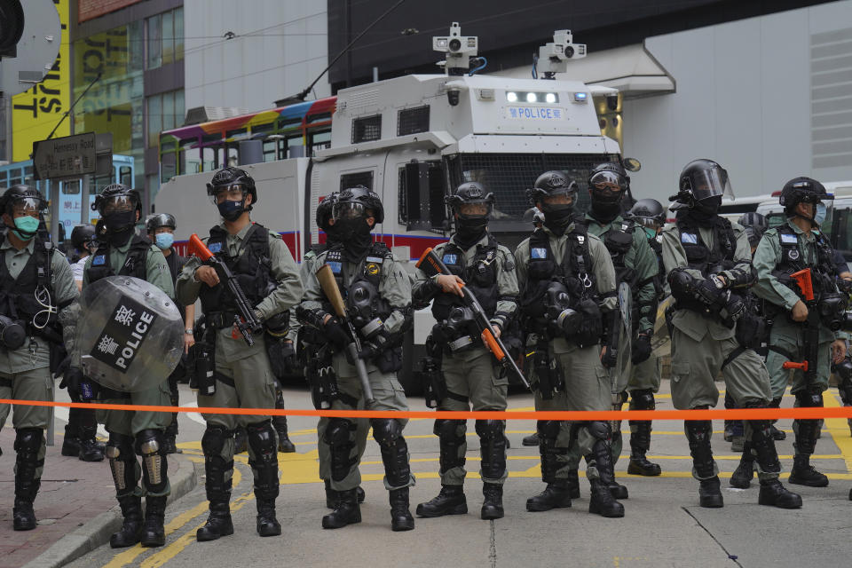 Riot police stand in formation in front of water cannon tuck during a protest against Beijing's national security legislation in Causeway Bay in Hong Kong, Sunday, May 24, 2020. Hong Kong police fired volleys of tear gas in a popular shopping district as hundreds took to the streets Sunday to march against China's proposed tough national security legislation for the city. (AP Photo/Vincent Yu)