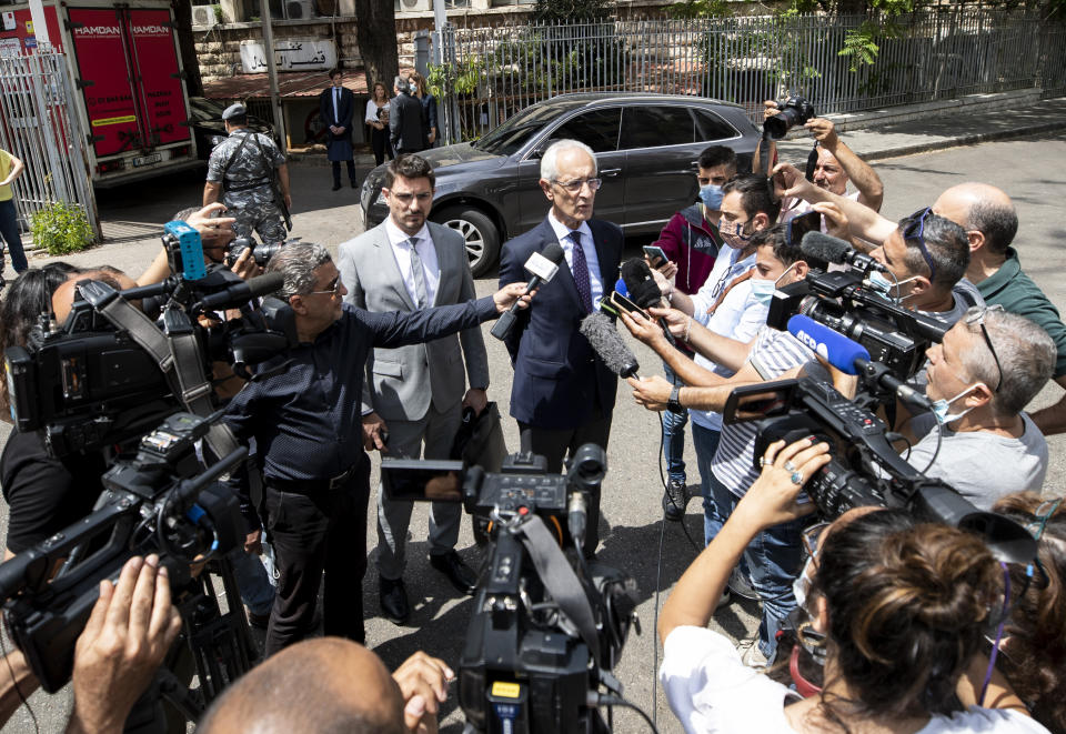 Members of Carlos Ghosn's defense team, lawyer Jean Yves Le Borgne, center right, and Jean Tamalet, center left, speak with journalist outside the Justice Palace in Beirut, Lebanon, Friday, June 4, 2021. Lawyers of Ex-Nissan boss Carlos Ghosn said on Friday their client has answered hundreds of questions by French and Lebanese investigators over the past week describing him as "happy and satisfied" to be given the opportunity to explain himself over accusations of financial misconduct. (AP Photo/Hassan Ammar)