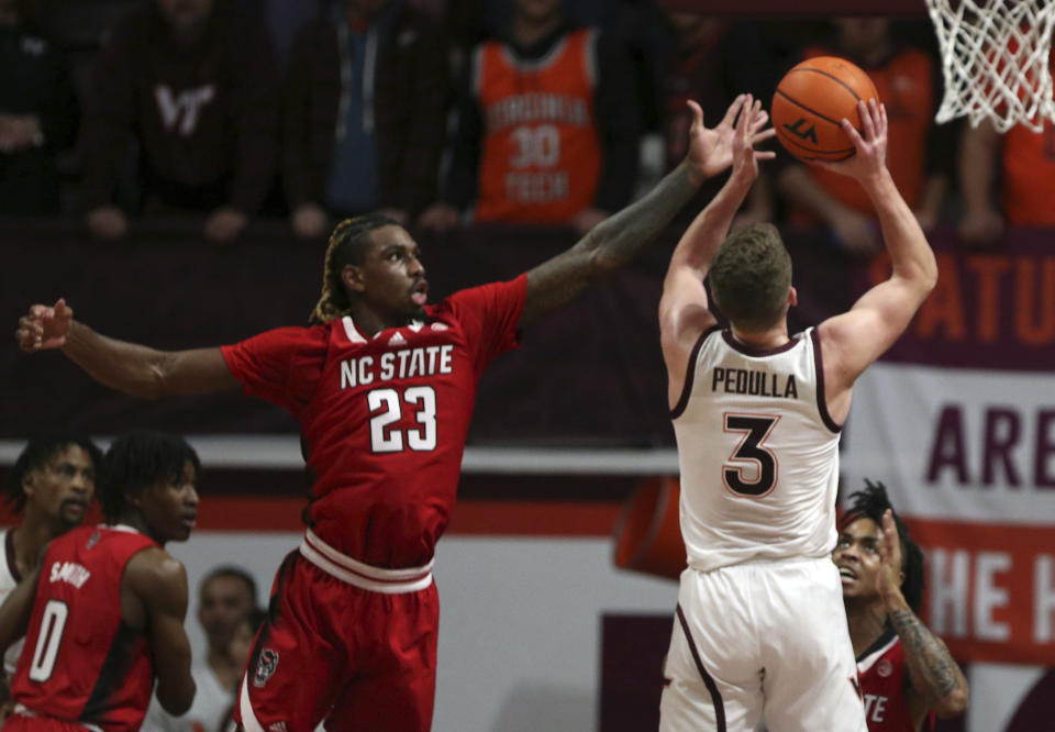 North Carolina State's Greg Gantt (23) defends as Virginia Tech's Sean Pedulla (3) shoots during the first half of an NCAA college basketball game Saturday, Jan. 7, 2023, in Blacksburg, Va. (Matt Gentry/The Roanoke Times via AP)