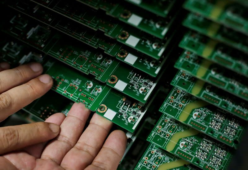 FILE PHOTO: An employee works on the production line of a television factory under Zhaochi Group in Shenzhen