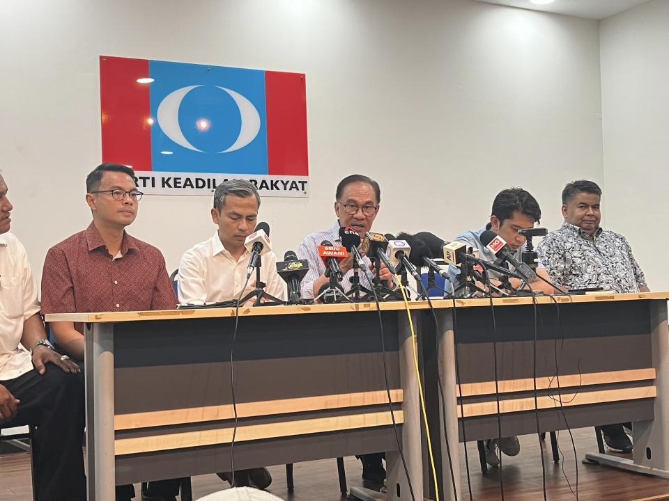 Malaysian opposition leader Anwar Ibrahim, center, speaks during a press conference at his party headquarters in Petaling Jaya, Malaysia, Thursday, Oct. 13, 2022. Anwar says he is optimistic that his opposition alliance is able to strive for a simple majority in general elections expected to be held next month. (AP Photo/Eileen Ng)