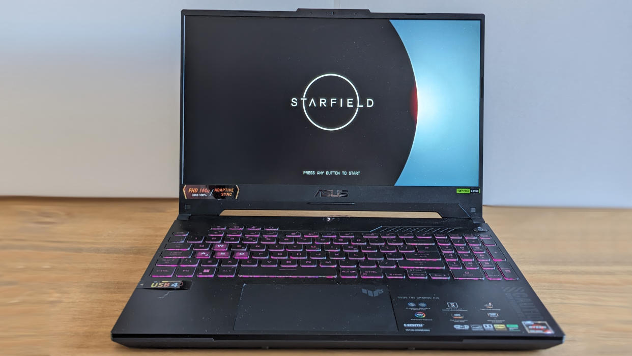  A black ASUS TUF Gaming A15 laptop on a wooden table. 