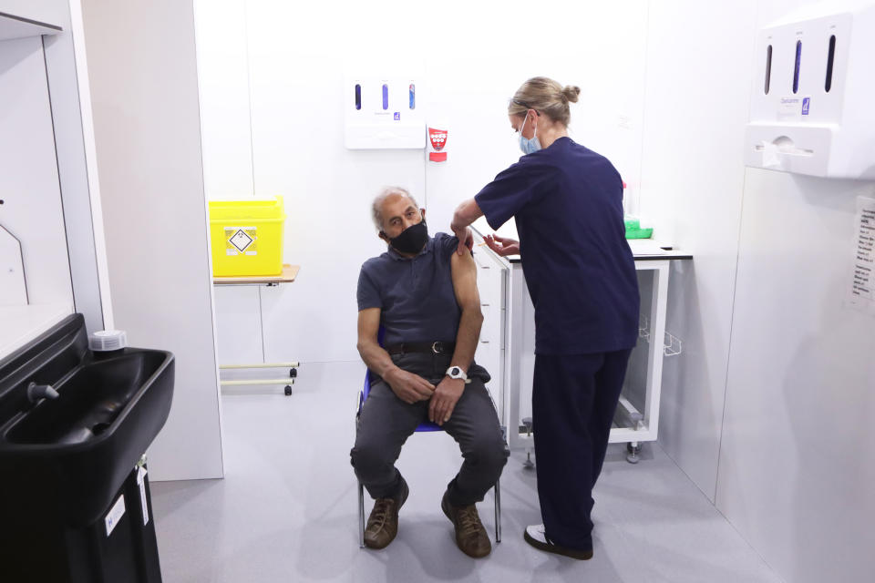 Olivia Smart, advanced practioner and Leeds Ladies FC defender, vaccinates Mewa Singh Khela, 72, with his first dose of the Oxford/AstraZeneca coronavirus vaccine at the Elland Road vaccination centre in Leeds. Picture date: Monday February 8, 2021.