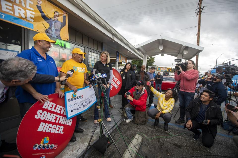 Joe Jr, left, in blue shirt and his father Joe Chahayed, middle, holding a check for $1,000,000