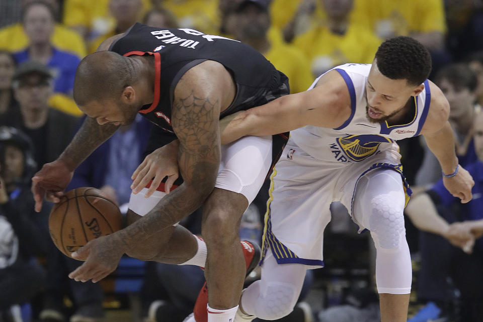 Houston Rockets forward PJ Tucker, left, grabs the ball next to Golden State Warriors guard Stephen Curry during the first half of Game 1 of a second-round NBA basketball playoff series in Oakland, Calif., Sunday, April 28, 2019. (AP Photo/Jeff Chiu)