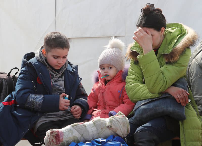 A woman sits with children at a temporary accommodation centre in Bezimenne