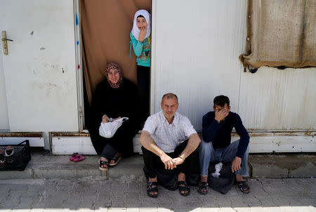 Syrian refugees sit outside their container at Harran refugee camp in the Sanliurfa province, Turkey April 26, 2016. REUTERS/Umit Bektas