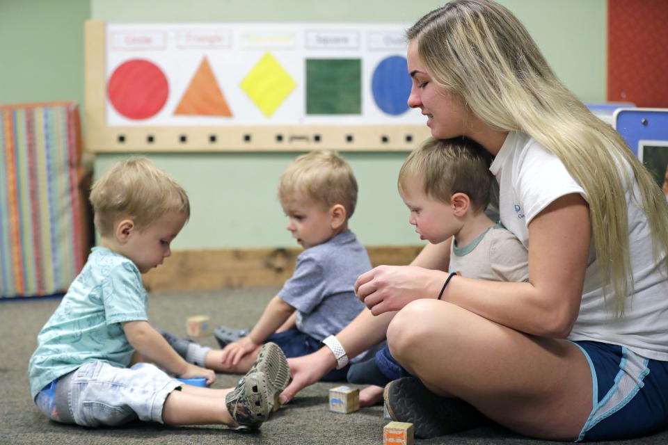 Assitant teacher Taylor Schulz plays with Aydin Schumacher, left, Landon Thiel, and Boone Heller, right, in the Sunshine classroom for one-year-olds at Inspire Dreams Group Child Care Wednesday, August 31, 2022, in Chilton, Wis.