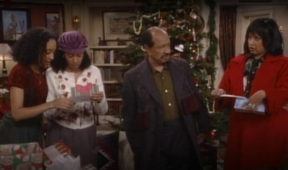 Characters Tamera Campbell, Tia Landry, Grandpa Campbell, and Lisa Landry gather by the Christmas tree in "Sister, Sister"