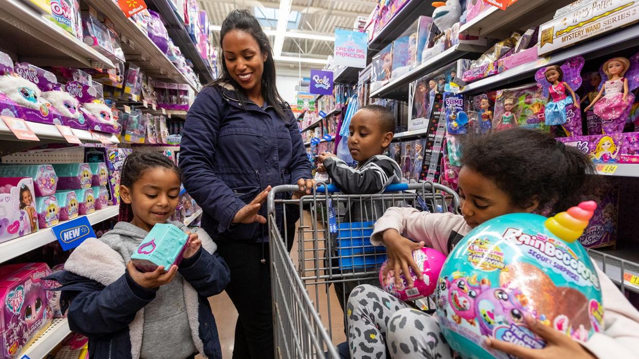 A family shops in Walmart's toy aisle. The supercenter will offer deals on toys, appliances and electronics on Black Friday.