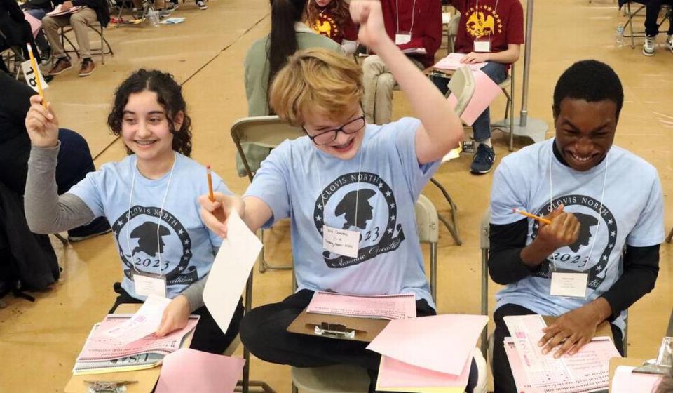 Clovis North students Keira Battista, Will Cravens and Kingdavid Egbe react after a correct response during the Super Quiz portion of the 2023 Fresno County Academic Decathlon.