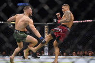 Dustin Poirier, right, kicks Conor McGregor during a UFC 264 lightweight mixed martial arts bout Saturday, July 10, 2021, in Las Vegas. (AP Photo/John Locher)