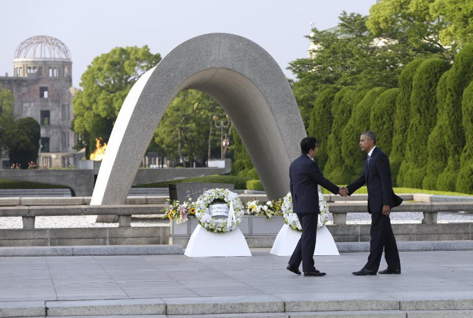 El presidente de Estados Unidos, Barack Obama, a la derecha, y el primer ministro japonés, Shinzo Abe, se estrechan la mano tras colocar ofrendas florales en el parque de la Paz en Hiroshima, Japón, el viernes 27 de mayo de 2016. (AP Foto/Carolyn Kaster)