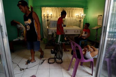 Jennelyn Olaires, 26, (R) sleeps on chairs at the wake of her partner Michael Siaron in Pasay, Metro Manila, Philippines July 28, 2016. REUTERS/Czar Dancel