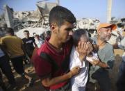 A Palestinian man reacts as people search for victims under the rubble of a house, which witnesses said was destroyed in an Israeli air strike, in Rafah in the southern Gaza Strip July 29, 2014. REUTERS/Ibraheem Abu Mustafa