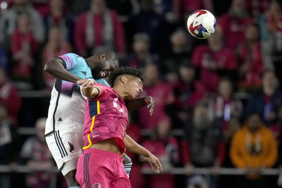 Minnesota United's Kemar Lawrence, left, and St. Louis City's Nicholas Gioacchini battle for the ball during the first half of an MLS soccer match Saturday, April 1, 2023, in St. Louis. (AP Photo/Jeff Roberson)