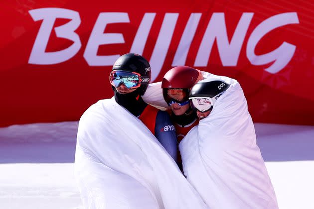 Mikaela Shiffrin, center, huddles with U.S. teammates Tommy Ford and Paula Moltzan after the mixed team parallel final. (Photo: Alex Pantling via Getty Images)