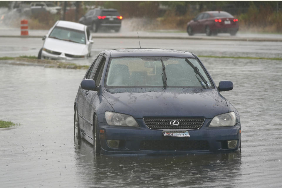 Cars that stalled in high water sit in receding flood waters in Dallas, Monday, Aug. 22, 2022. (AP Photo/LM Otero)