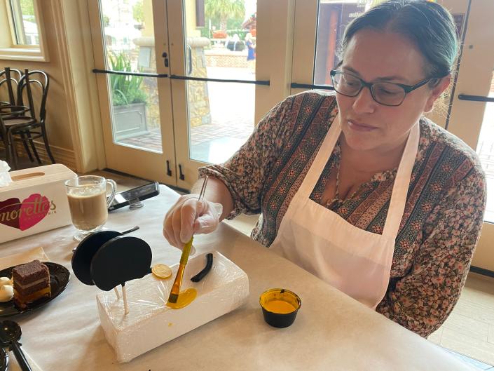 Author&#39;s friend painting parts of cake.