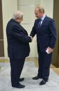 Russian President Vladimir Putin (R) welcomes Syrian Foreign Minister Walid Muallem (L) during their meeting at the residence of Bocharov Ruchei in Sochi on November 26, 2014