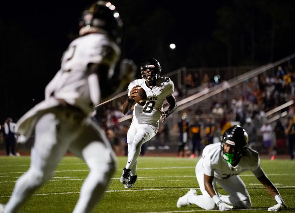 Golden Gate Titans quarterback Sam Powell (8) rolls out of the pocket before throwing a touchdown during the second quarter of a district game against the Naples Golden Eagles at Staver Field in Naples on Thursday, Sept. 14, 2023.