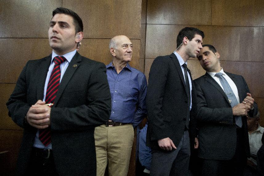 Former Israeli Prime Minister Ehud Olmert, center, attends a hearing at Tel Aviv's District Court, Monday, March 31, 2014. The court handed down the verdict in the wide-ranging Jerusalem real estate scandal case related to Olmert’s activities before becoming prime minister in 2006. A total of 13 government officials, developers and other businesspeople were charged in three separate schemes. (AP Photo/Dan Balilty, Pool)
