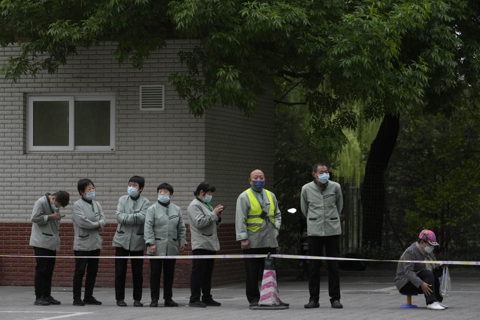 Residents line up for COVID test, Wednesday, April 27, 2022, in Beijing. Workers put up fencing and police restricted who could leave a locked-down area in Beijing on Tuesday as authorities in the Chinese capital stepped up efforts to prevent a major COVID-19 outbreak like the one that has all but shut down the city of Shanghai. (AP Photo/Ng Han Guan)