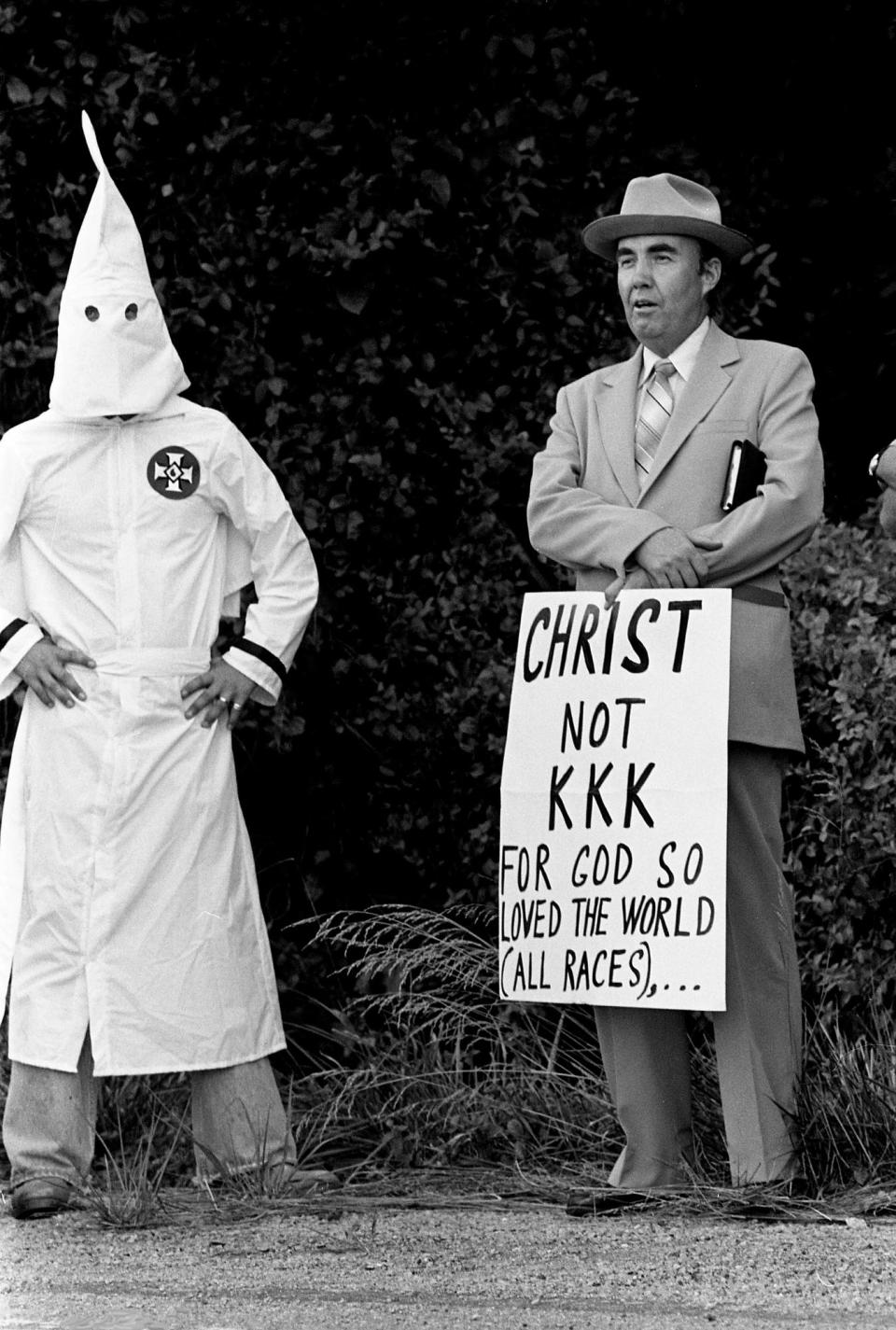 The Rev. Mel Perry, right, of Nashville is being confronted by a hooded Ku Klux Klan member as he protests alone at their wedding and rally off of Route 64 near Pulaski, Tenn. July 12, 1980.
