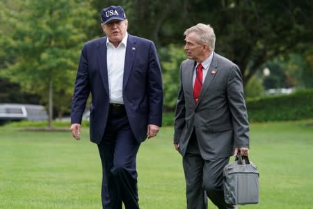 U.S. President Donald Trump walks with Rear Admiral Peter J. Brown, Assistant Commandant for Response Policy, as he returns from Camp David to the White House in Washington