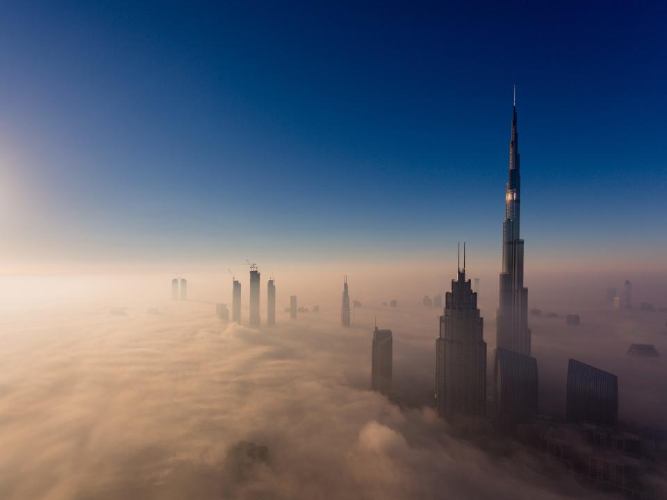 The Burj Khalifa emerges high above the clouds in Dubai.