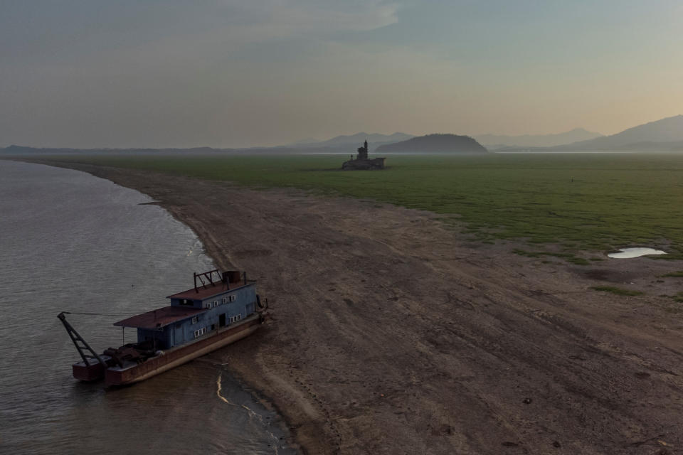 An aerial view shows a grounded ship near Louxingdun island in Poyang Lake which exhibits low water levels because of a regional drought in Lushan, Jiangxi province, China, August 24, 2022.  REUTERS/Thomas Peter