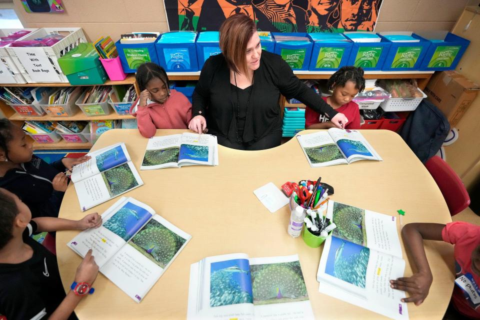 Hawthorne School first-grade teacher Megan Lee works with students, including D'Laila Epps (left of Lee) and Messiah Scott (right of Lee) on a reading and spelling lesson.